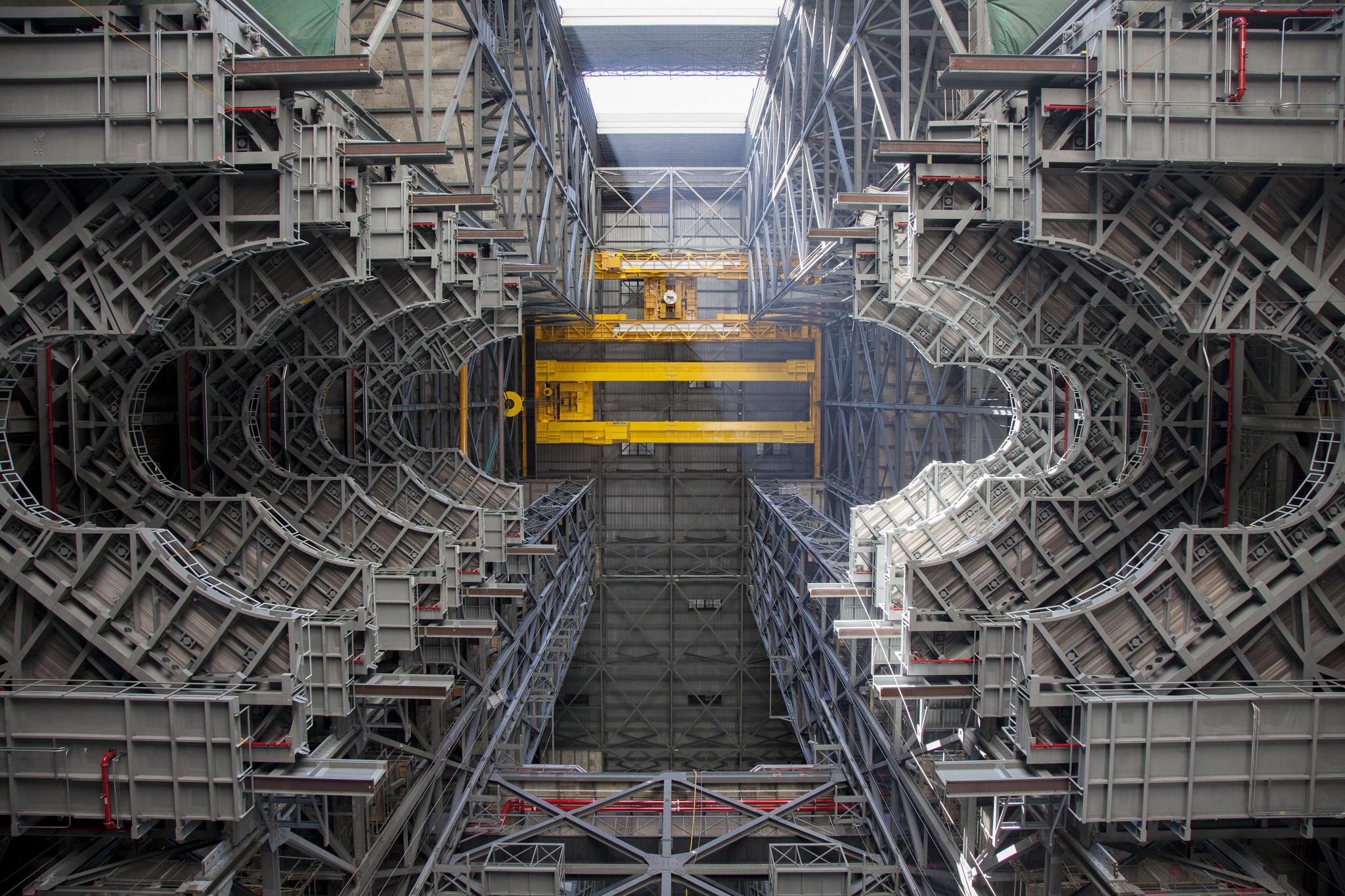 A heavy-lift crane lifts the first half of the F-level work platforms, F south, for NASA’s Space Launch System rocket, into position for installation July 15, in High Bay 3 of the Vehicle Assembly Building at NASA’s Kennedy Space Center in Florida. Photo credit: NASA/Bill White