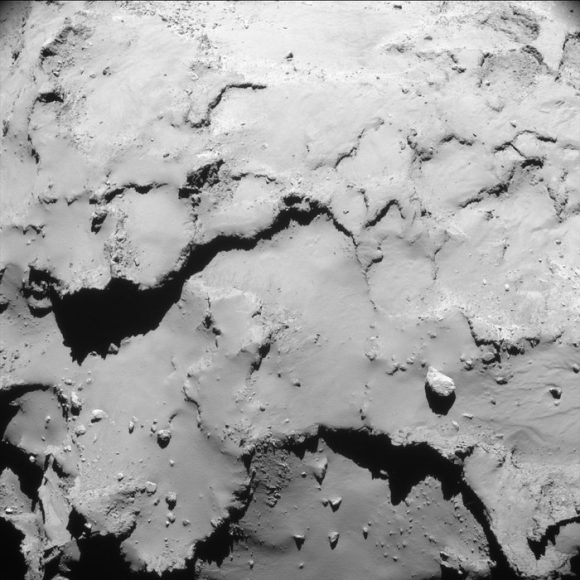 Single frame enhanced NavCam image taken on September 30, 2016 at 00:27 GMT, when Rosetta was 18.1 km from the center of the nucleus of Comet 67P/Churyumov-Gerasimenko. The scale at the surface is about 1.5 m/pixel and the image measures about 1.6 km across. ESA/Rosetta/NAVCAM – CC BY-SA IGO 3.0.