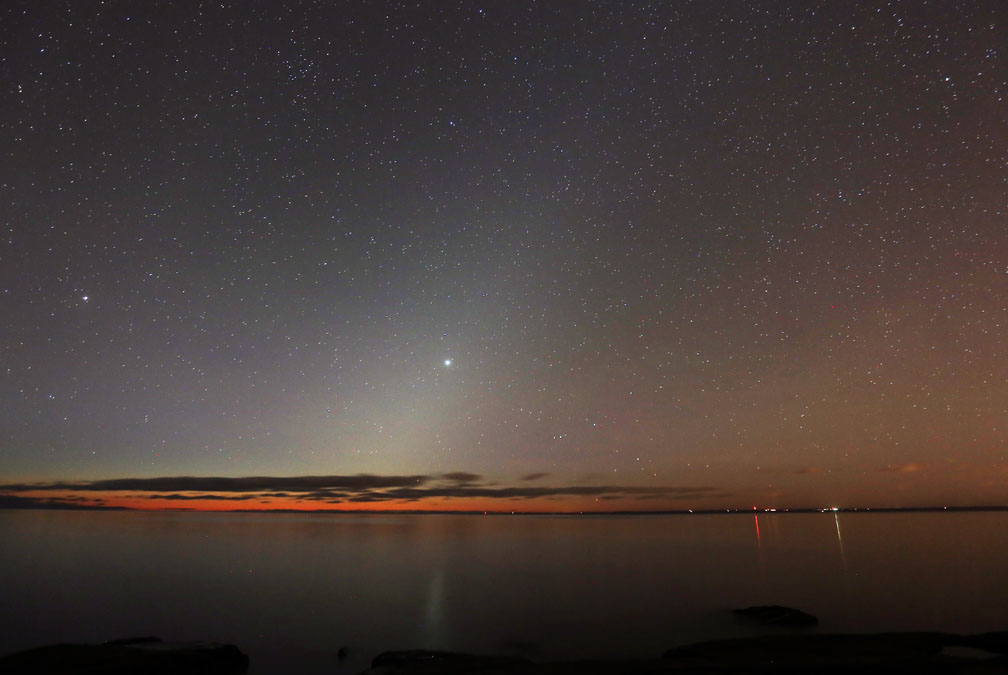 The zodiacal light punctuated by the planet Jupiter reflects off Lake Superior near Duluth, Minn. this morning (Nov. 8). The book describes nighttime lights such as the zodiacal, gegenschein, airglow and lunar halo and corona phenomena. Credit: Bob King