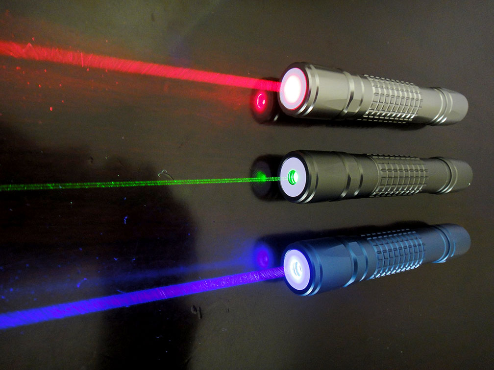 Green, violet and red lasers. Lasers emit very specific colors of light. Green appears brightest and sharpest; red and blue beams look fuzzier to our eyes. Credit: Pang Ka kit / CC BY-SA 3.