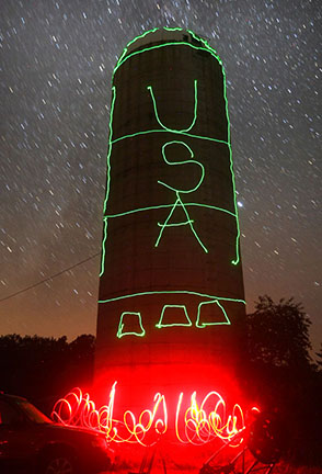 Lasers can be artistic tools, too. Every year, a friend holds a star party near a towering grain silo. Late at night, we take a break, open the camera shutter and paint the silo with laser light. In this case - a rocket. Credit: Bob King