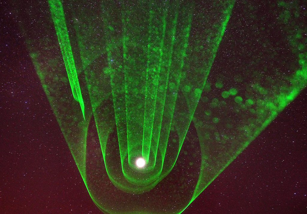 Lasers form visible beams because they scatter off air molecules, water vapor and dust in the air. In this photo, I spun the beam around the planet Jupiter on a humid, slightly foggy night. Credit: Bob King