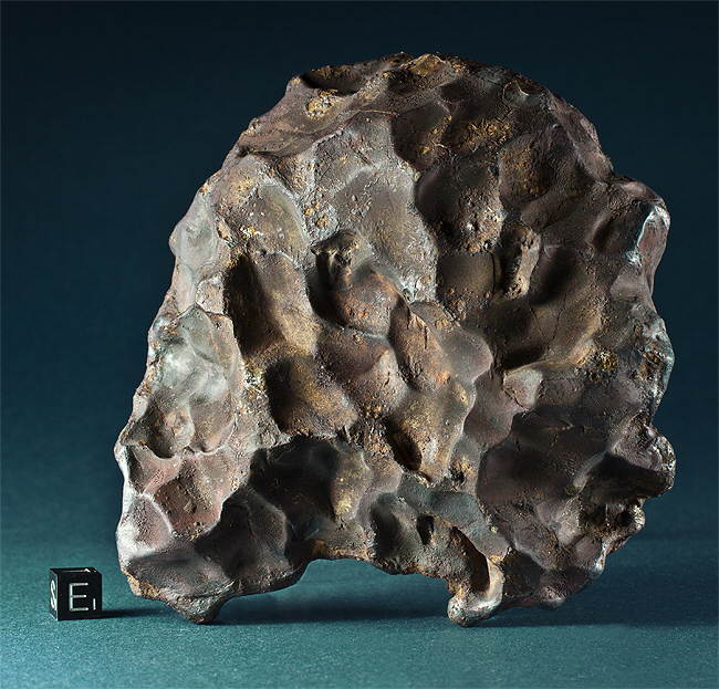 A naturally sculpted iron-nickel meteorite recovered from the Sikhote-Alin meteorite fall in February 1947. The dimpling or "thumb-printing" occurs when softer minerals are melted and sloughed away as the meteorite is heated by the atmosphere while plunging to Earth. Credit: Svend Buhl