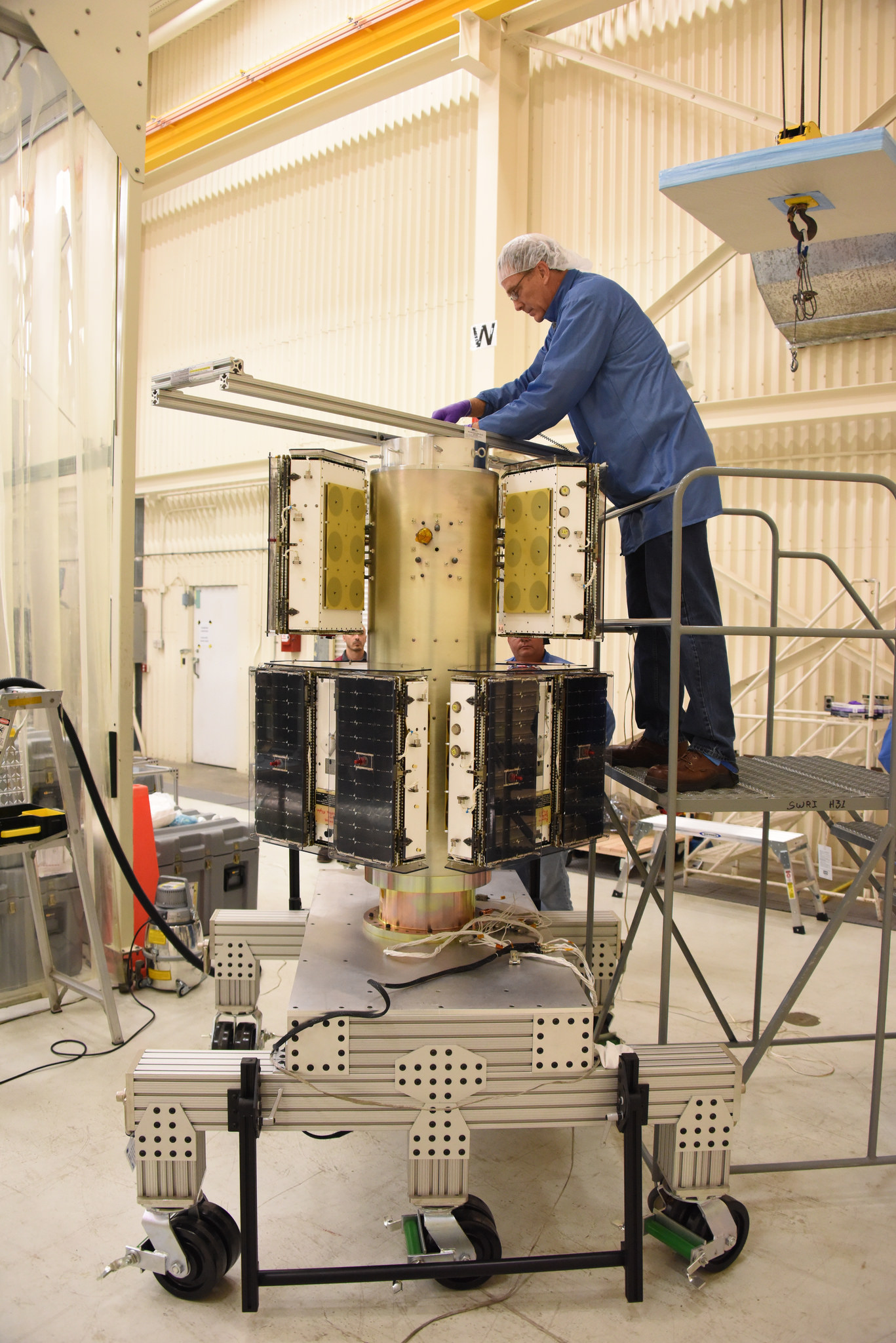 An Orbital ATK technician checks the installation of two of the eight the CYGNSS microsatellites on their deployment module at Vandenberg Air Force Base in California.  Credits: Photo credit: USAF 