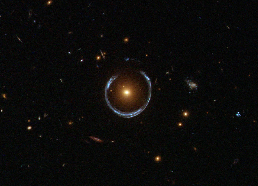 Hubble image of a luminous red galaxy (LRG) gravitationally distorting the light from a much more distant blue galaxy, a technique known as gravitational lensing. Credit: ESA/Hubble & NASA