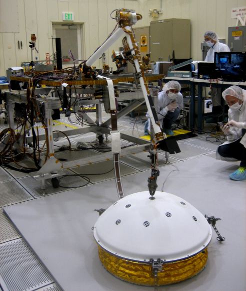 In this image, InSight's Instrument Deployment Arm is practicing placing SEIS on the surface. Image: NASA/Lockheed Martin