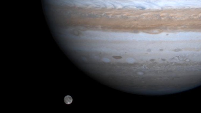 Jupiter's moon Ganymede, the largest moon in the Solar System, seen orbiting Jupiter, the largest planet in the Solar System. This image was taken by the Cassini spacecraft. Image Credit: NASA/JPL/University of Arizona