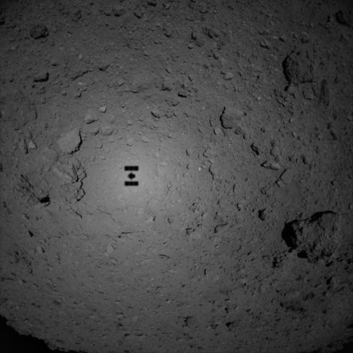 An image from one of Hayabusa2's close approaches to Ryugu. The silhouette of the spacecraft is clearly visible. Hey, it looks like a Canada flag! Image Credit: JAXA