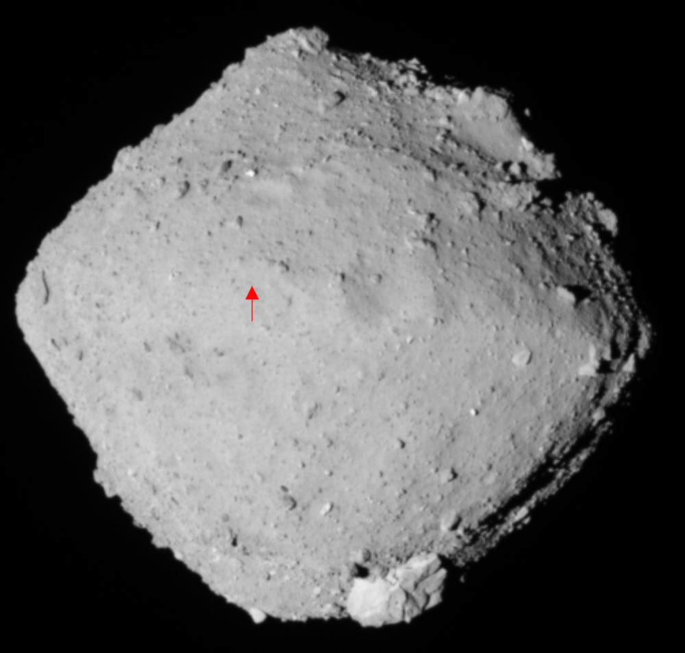 Asteroid Ryugu, as imaged by the Hayabusa2 spacecraft. The red dot marks the sampling location. Image Credit: JAXA/Hayabusa2