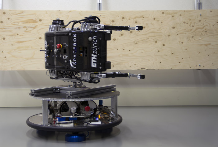 SpaceBok mounted on its side at ORBIT. By bouncing off the plywood walls with its legs, it was able to simulate performance on extremely low-gravity objects like asteroids. Image Credit:    ETH Zurich/ZHAW Zurich