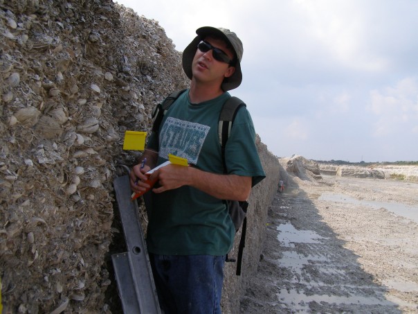 The wall of the quarry is filled with fossilized sea shells. This image shows Mike Meyer on a quarry excavation trip in 2006. Image Credit: Mike Meyer