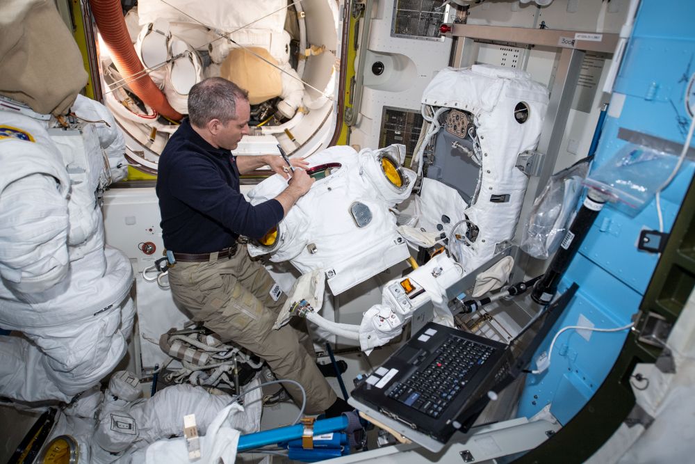 Canadian astronaut David Saint-Jacques seen inside the Quest airlock replacing the Hard Upper Torso (HUT) on an Extravehicular Mobility Unit (EMU) aboard the International Space Station. Replacing the Hard Upper Torso (HUT) can take up to 12 hours. Image Credit: NASA/CSA