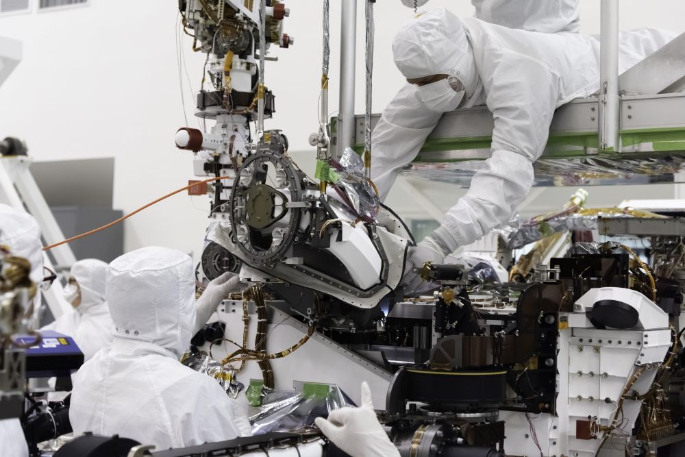 NASA engineers working on the Mars 2020 rover's sample return mechanism. What kind of protection is necessary when these samples return to Earth? Image Credit: NASA