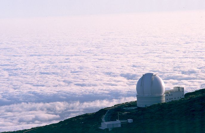 The William Herschel Telescope at La Palma, with a sea of clouds below it. Image Credit: Unknown. http://creativecommons.org/licenses/by-sa/3.0/