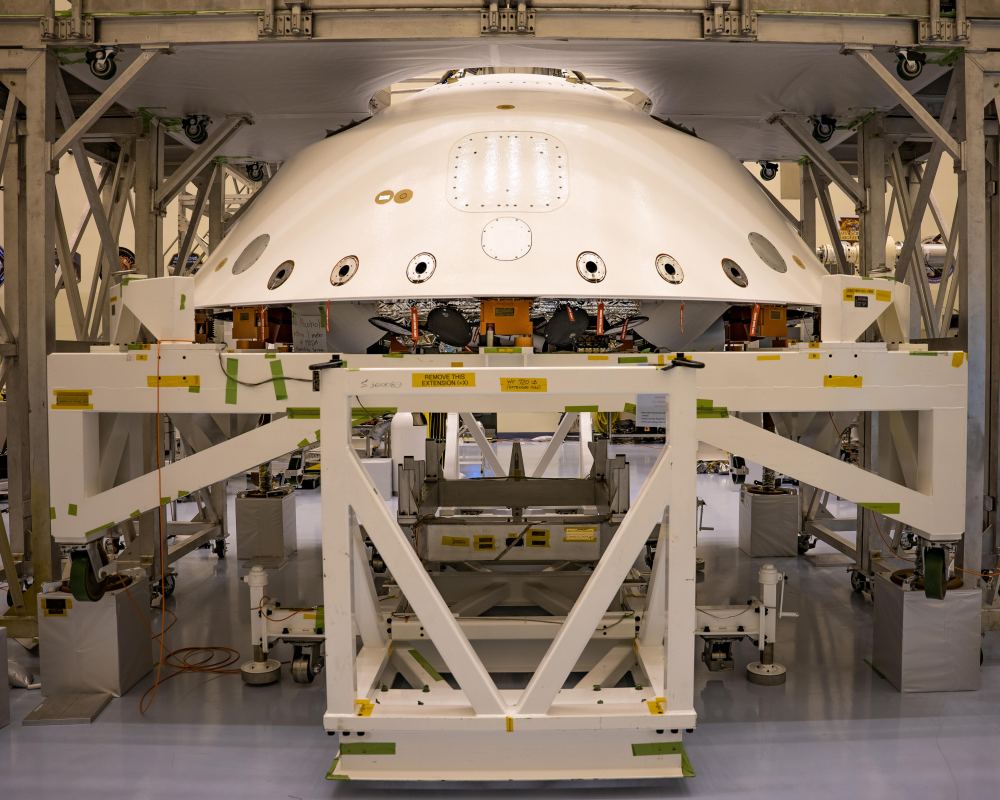The cone-shaped back shell for NASA's Perseverance rover mission sits on a support structure in this April 29, 2020, image from Kennedy Space Center in Florida. Along with the heat shield, the back shell provides protection for the rover and descent stage during Martian atmospheric entry. Portions of the descent stage and rover, stacked one on top of the other, can be seen in the open area directly below the lower edge of back shell. Image Credit: NASA/JPL-Caltech