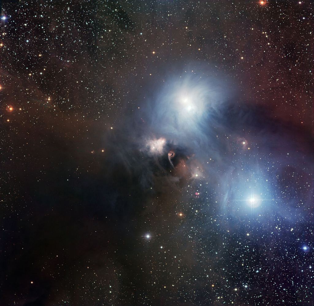 This magnificent view of the region around the star R Coronae Australis was created from images taken with the Wide Field Imager (WFI) at ESO’s La Silla Observatory in Chile. R Coronae Australis lies at the heart of a nearby star-forming region and is surrounded by a delicate bluish reflection nebula embedded in a huge dust cloud. The complex is named after the star R Coronae Australis, which lies at the centre of the image. Image Credit: By ESO - European Southern Observatory, CC BY 3.0, https://commons.wikimedia.org/w/index.php?curid=10831490