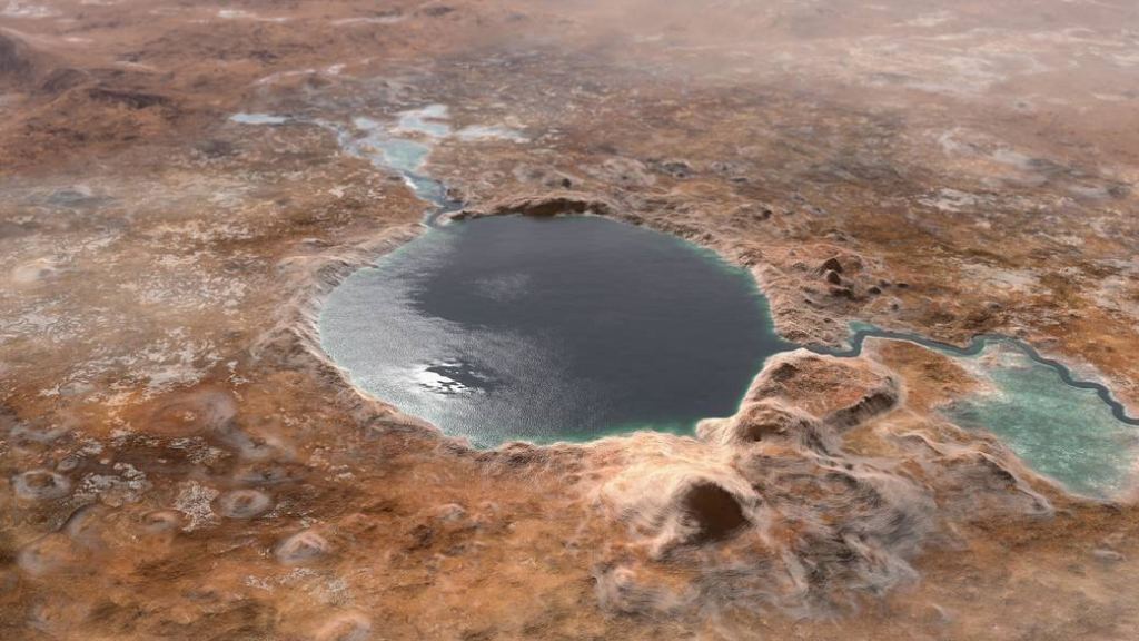 This illustration shows Jezero Crater — the landing site of the Mars 2020 Perseverance rover — as it may have looked billions of years ago on Mars when it was a lake. An inlet and outlet are also visible on either side of the lake. Image Credit: NASA/JPL-Caltech 