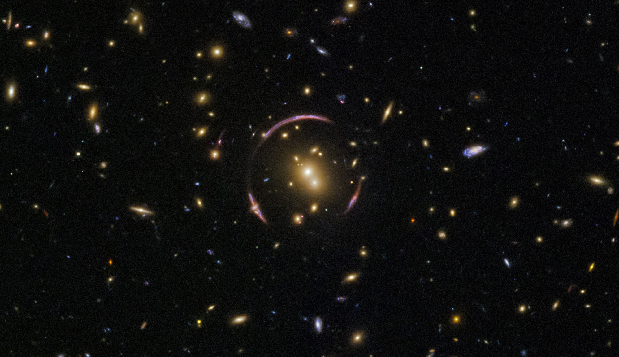 Hubble image of SDSSJ0146-0929, a galaxy cluster that is massive enough to severely distort the spacetime around it. There's the mass of the visible stars and gas, but there's also a hidden amount of dark matter that adds to the cluster's mass. Credit: ESA/Hubble & NASA; Acknowledgment: Judy Schmidt
