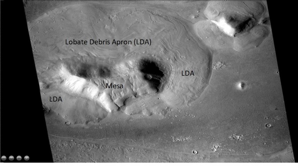 This image from the Mars Reconnaissance Orbiter's CTX camera shows a mesa with three lobate debris aprons in Mars' Ismenius Lacus quadrangle. Though these LDAs aren't from a glacier, they illustrate the concept. Image Credit: By Jim Secosky modified NASA image NASA/JPL/University of Arizona/Secosky - http://viewer.mars.asu.edu/planetview/inst/ctx/D02_028115_2225_XI_42N341W#P=D02_028115_2225_XI_42N341W&T=2, Public Domain, https://commons.wikimedia.org/w/index.php?curid=66634749