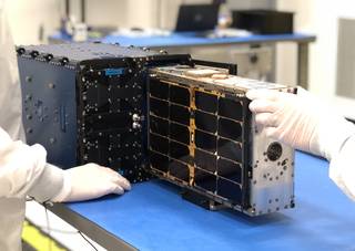 CubeSat containing the Hydros system being loaded onto a CubeSat deployer.