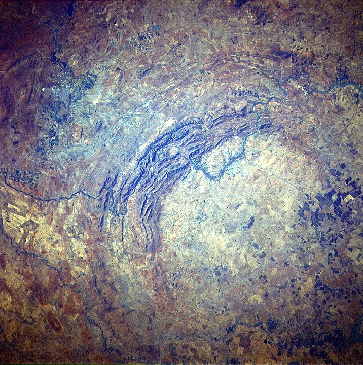 The Vredefort crater dome as seen from space on the STS-51-I mission. It was created by the impact of a large object about two billion years ago. The new research letter claims it could be the result of a long-period comet ripped apart by the Sun's tidal forces, with one of the fragments striking Earth. By Júlio Reis (User:Tintazul) - [1], Public Domain, https://commons.wikimedia.org/w/index.php?curid=400487
