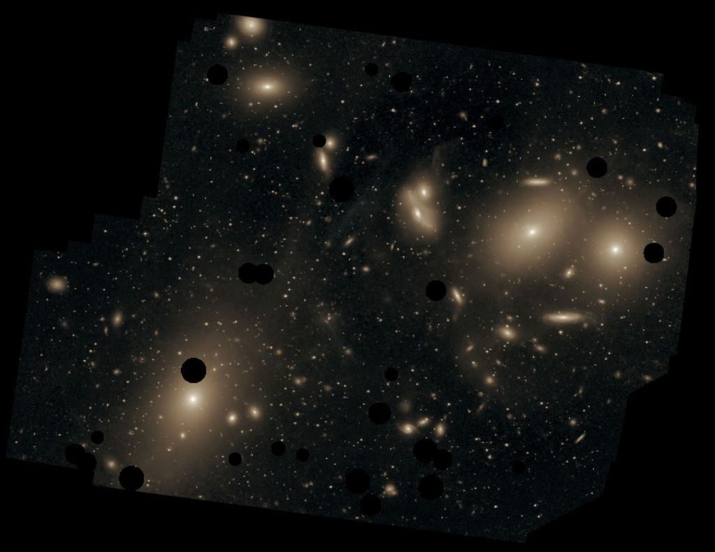This deep image of the Virgo Cluster obtained by Chris Mihos and his colleagues using the Burrell Schmidt telescope shows the diffuse light between the galaxies belonging to the cluster. North is up, east to the left. The dark spots indicate where bright foreground stars were removed from the image. Messier 87 is the largest galaxy in the picture (lower left). Image Credit: By Chris Mihos (Case Western Reserve University)/ESO -  CC BY 4.0