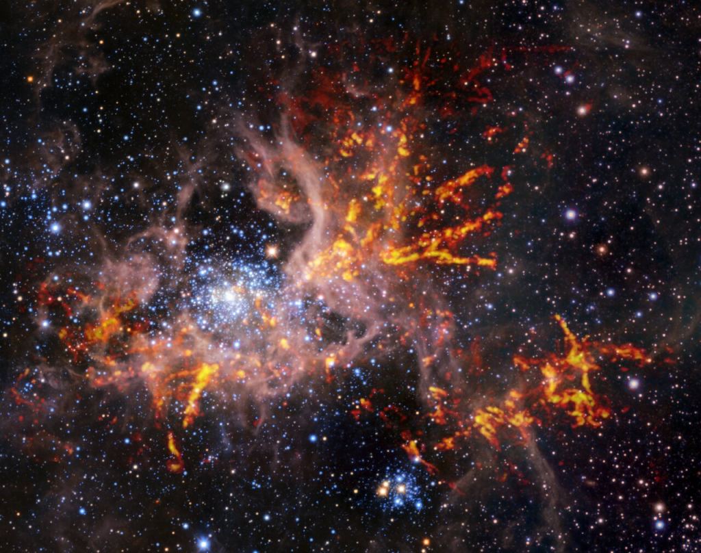 This composite image shows the star-forming region 30 Doradus, also known as the Tarantula Nebula. The background image, taken in the infrared, is itself a composite: it was captured by the HAWK-I instrument on ESO’s Very Large Telescope (VLT) and the Visible and Infrared Survey Telescope for Astronomy (VISTA), shows bright stars and light, pinkish clouds of hot gas. The bright red-yellow streaks that have been superimposed on the image come from radio observations taken by the Atacama Large Millimeter/submillimeter Array (ALMA), revealing regions of cold, dense gas which have the potential to collapse and form stars. The unique web-like structure of the gas clouds led astronomers to the nebula’s spidery nickname.