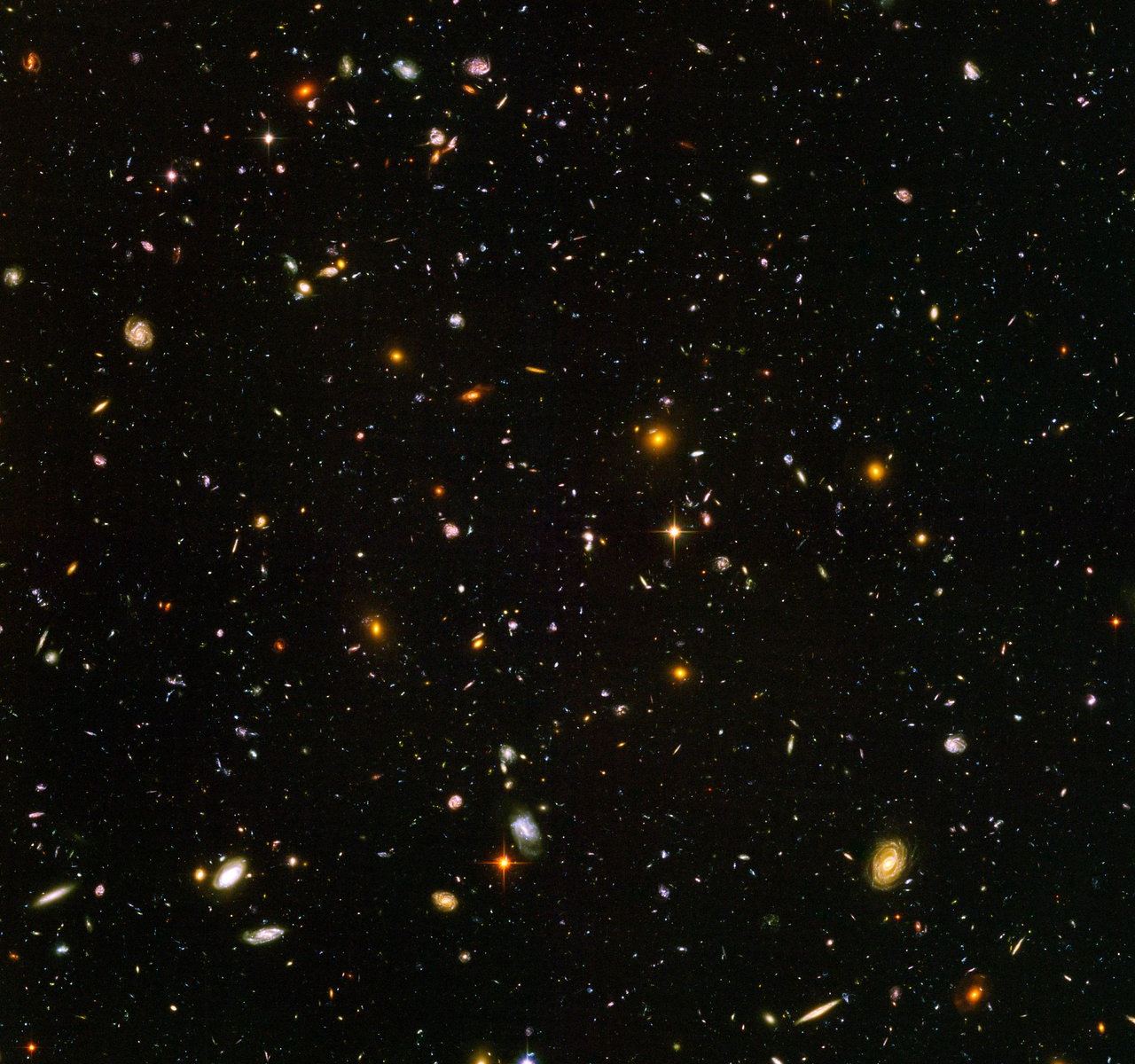 This view of nearly 10,000 galaxies is called the Hubble Ultra Deep Field. It shows some galaxies in the early Universe, (which appear as red blobs). Credit: NASA/ESA/HUDF