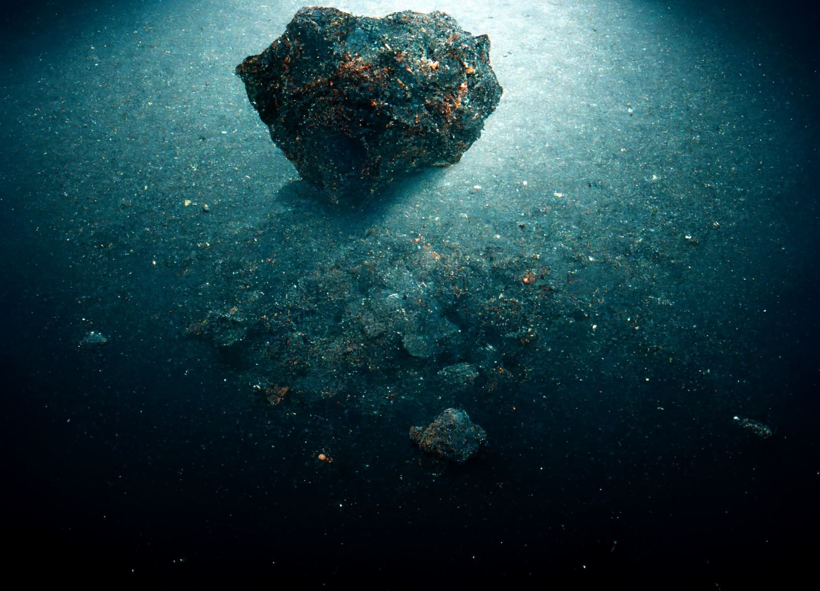 Artist's illustration of a meteorite resting on the floor of the ocean.