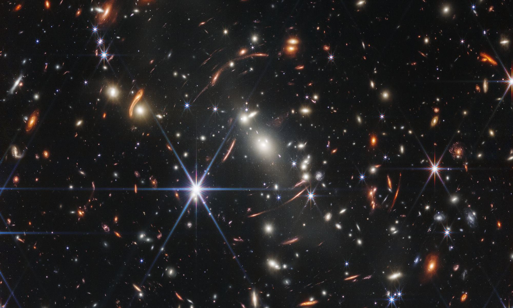 distant galaxies behind a nearby galaxy cluster.