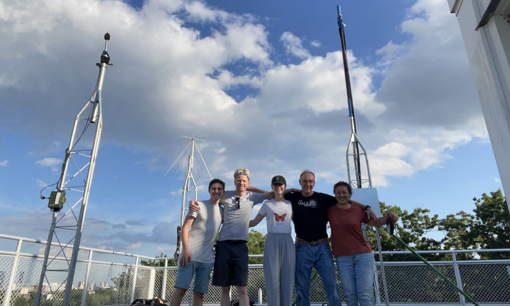 Galileo Project members (from left: Carson Ezell, Ezra Kelderman, Abby White, Alex and Lily Delacroix) with the audio tower (left), radar spectrum tower (middle) and radar imaging tower (right) behind them on the roof of the Harvard College Observatory.