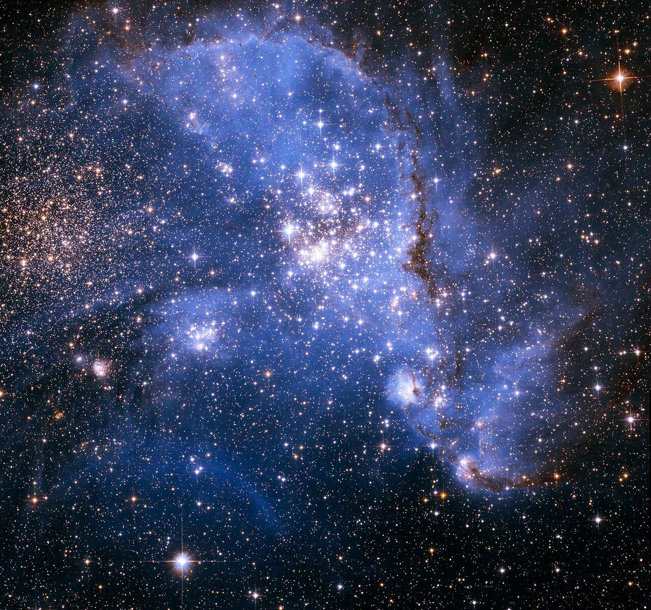 Image of NGC 346, a stellar nursery where astronomers have discovered newborn stars spiralling in towards the center of a nebula