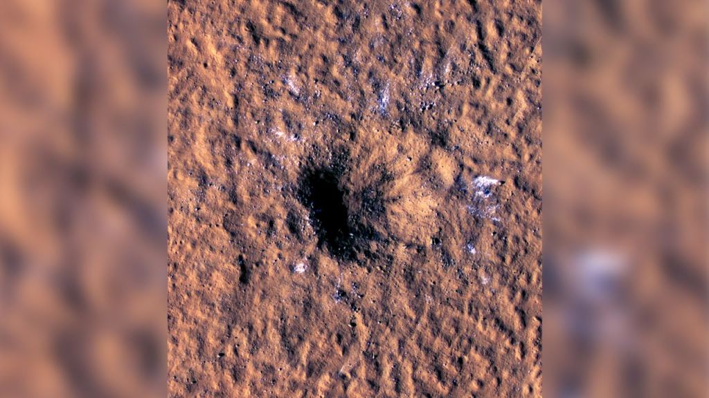 This image shows an impact crater from a meteorite in December 2021. The impact excavated boulder-size chunks of ice. The impactor was only 5 to 12 meters (16 to 39 feet) in diameter, so didn't generate nearly the heat that much larger impacts generate. The Mars Color Imager (MARCI) camera aboard NASA's Mars Reconnaissance Orbiter (MRO) captured the image. Image Credit: NASA/JPL-Caltech/University of Arizona