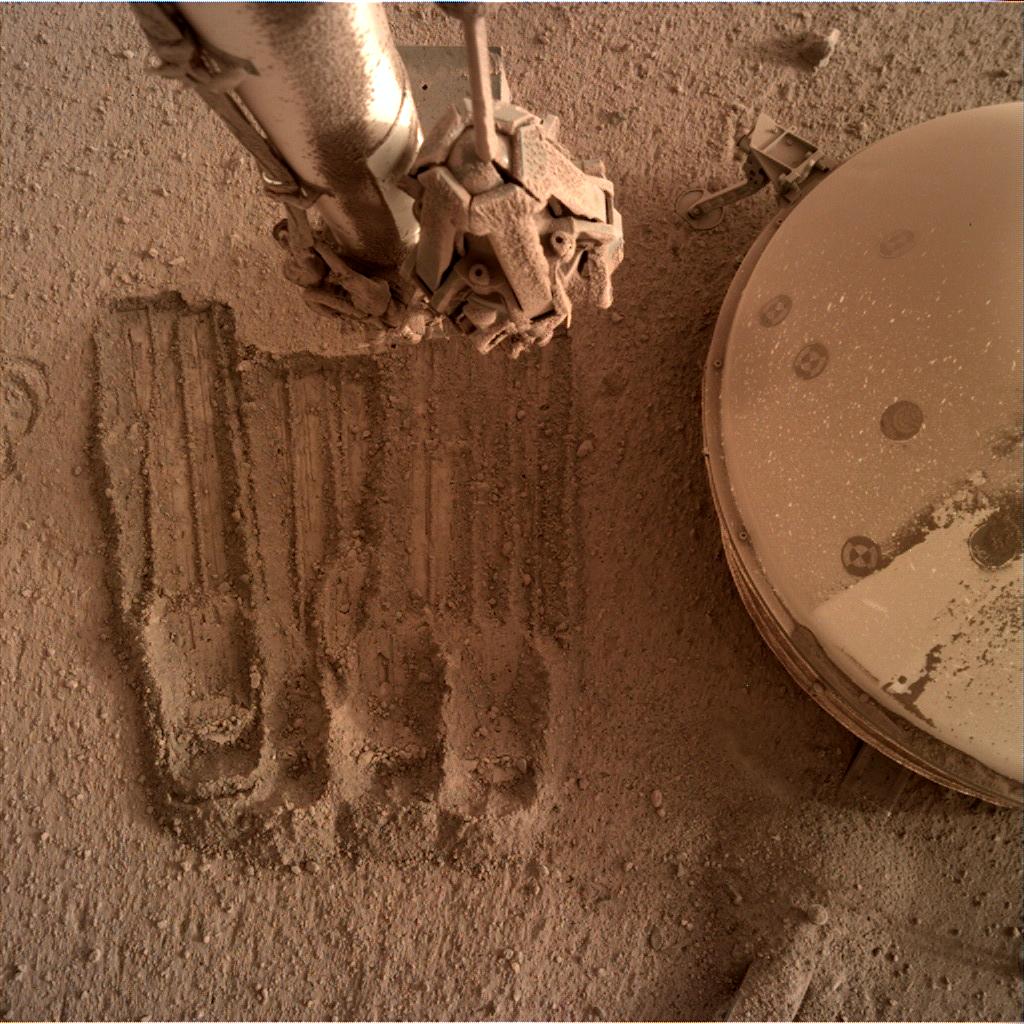 In another recent image, InSight uses its robotic arms to scratch away some of the regolith surrounding it.