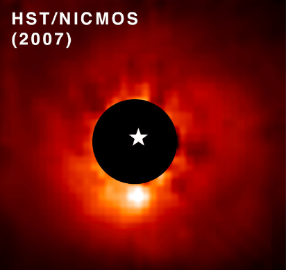 This Hubble image shows the star AB Aurigae and the exoplanet AB Aurigae b. Hubble's coronagraph (black circle) blocked out the light from the star, making the exoplanet brighter. The exoplanet is the bright patch below the coronagraph. The white star symbol marks AB Aurigae's position. Image Credit: NASA, ESA, T. Currie (Subaru Telescope, Eureka Scientific Inc.), A. Pagan (STScI); CC BY 4.0