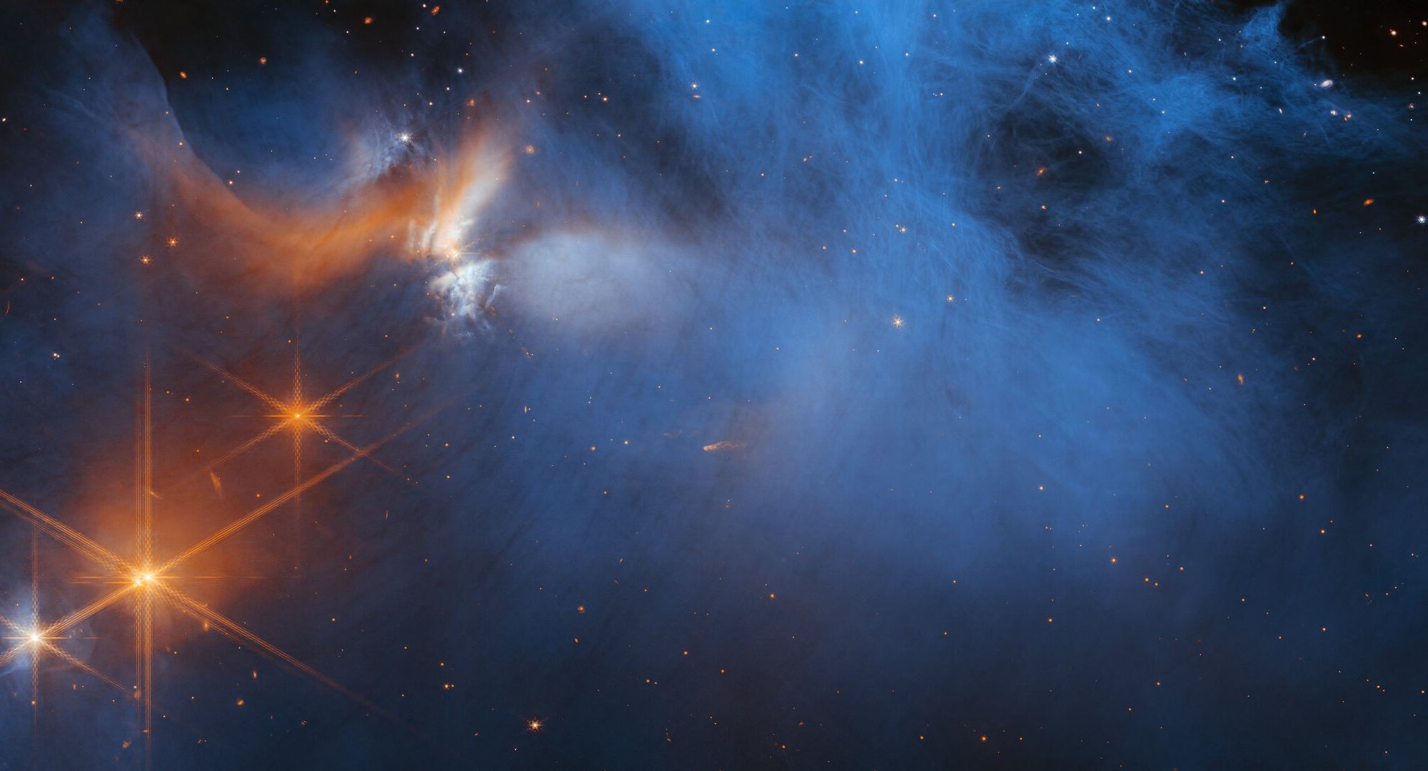 A large, dark cloud is contained within the frame. In its top half it is textured like smoke and has wispy gaps, while at the bottom and at the sides it fades gradually out of view. On the left are several orange stars: three each with six large spikes, and one behind the cloud which colours it pale blue and orange. Many tiny stars are visible, and the background is black.