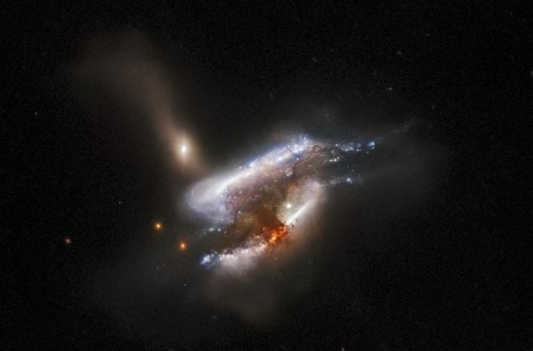 IC 2431 es otra fusión de triple galaxia a casi 700 millones de años luz de distancia. Las distorsiones de las mareas son obvias en esta imagen, y la fusión también está provocando la formación de estrellas. Crédito de la imagen: ESA/Hubble y NASA, W. Keel, Dark Energy Survey, DOE, FNAL, DECam, CTIO, NOIRLab/NSF/AURA, SDSS Reconocimiento: J. Schmidt