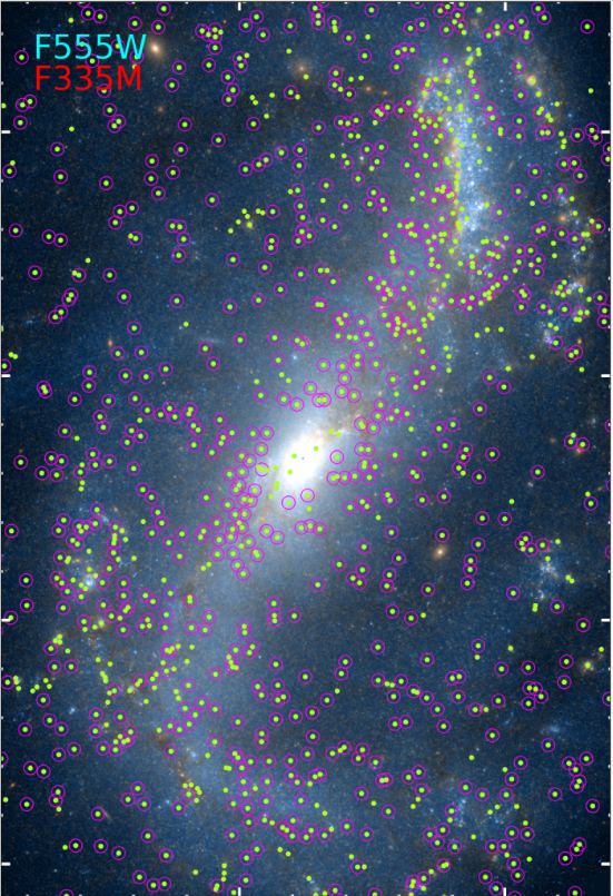 This image from the paper is a combination of Hubble (Blue F555W) and JWST (Red F335M) data from NGC 7496. The green dots are sources detected by the JWST, and the ones without a magenta circle are the strongest PAH emitters and mostly found in the main dust lanes within the spiral arms. This image is a good example of the scientific detail revealed in JWST images that lies underneath the beautiful visual detail we can more easily relate to. Image Credit: Rodríguez et al. 2023. 