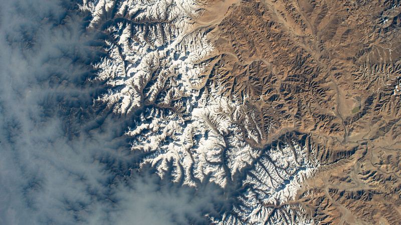 Clouds gather on Nepal's sub-tropical side of the Himalayas with Mount Everest at the center of this photograph taken by an external high definition camera on the International Space Station as it orbited 263 miles above the Indian subcontinent. Courtesy NASA.