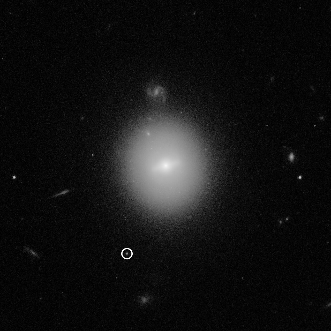 This Hubble Space Telescope image identified the location of an intermediate-mass black hole named J 2150 (3XMM J215022.4 055108), weighing over 50,000 times the mass of our Sun. The black hole is indicated by the white circle. This photo was taken with Hubble's Advanced Camera for Surveys. Image Credit: NASA, ESA, and D. Lin (University of New Hampshire)