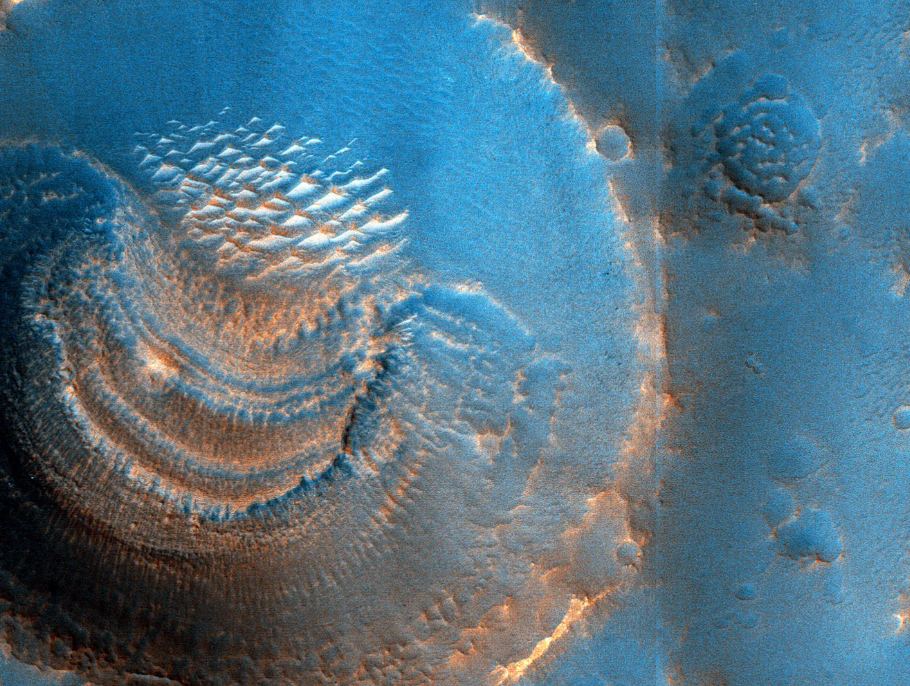 This HiRISE image of a Martian crater is processed to highlight its features. It contains unusual deposits possibly caused by sublimation. Image Credit: NASA/JPL/University of Arizona