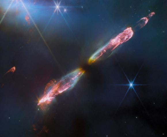 Wysokiej rozdzielczości zdjęcie Herbig-Haro 211 z Kosmicznego Teleskopu Jamesa Webba, wykonane w bliskiej podczerwieni, ujawnia niezwykłe szczegóły przepływu młodej, nowo powstałej gwiazdy, odpowiednika naszego Słońca z dzieciństwa.  Źródło zdjęcia: ESA/Web, NASA, CSA, Tom Ray (Dublin)