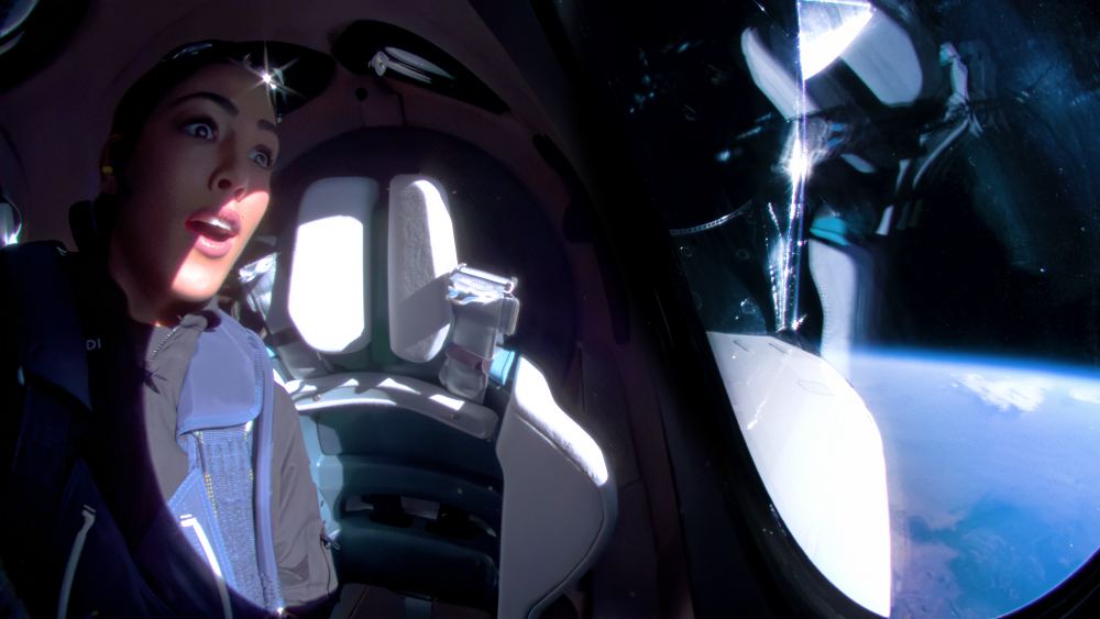 Kellie Gerardi tested a biomedical Astroskin, a blood glucose monitor, and monitored a fluids experiment during Virgin Galactic's 05 expedition. She also made time to simply gaze at the view out the portholes during flight. Courtesy Virgin Galactic. 