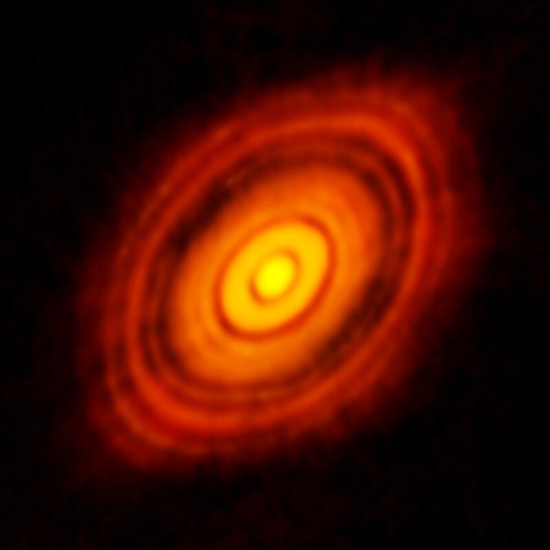This image is from ALMA, the Atacama Large Millimetre-submillimetre Array, and it shows the protoplanetary disk around a young star named HL Tauri. These ALMA observations reveal substructures within the disc that show the possible positions of planets forming in the dark patches within the system. As the planets gather mass, they 'sweep' lanes in the disk of matter, creating the dark gaps. It's next to impossible to see actual planets forming. Image Credit: ALMA.