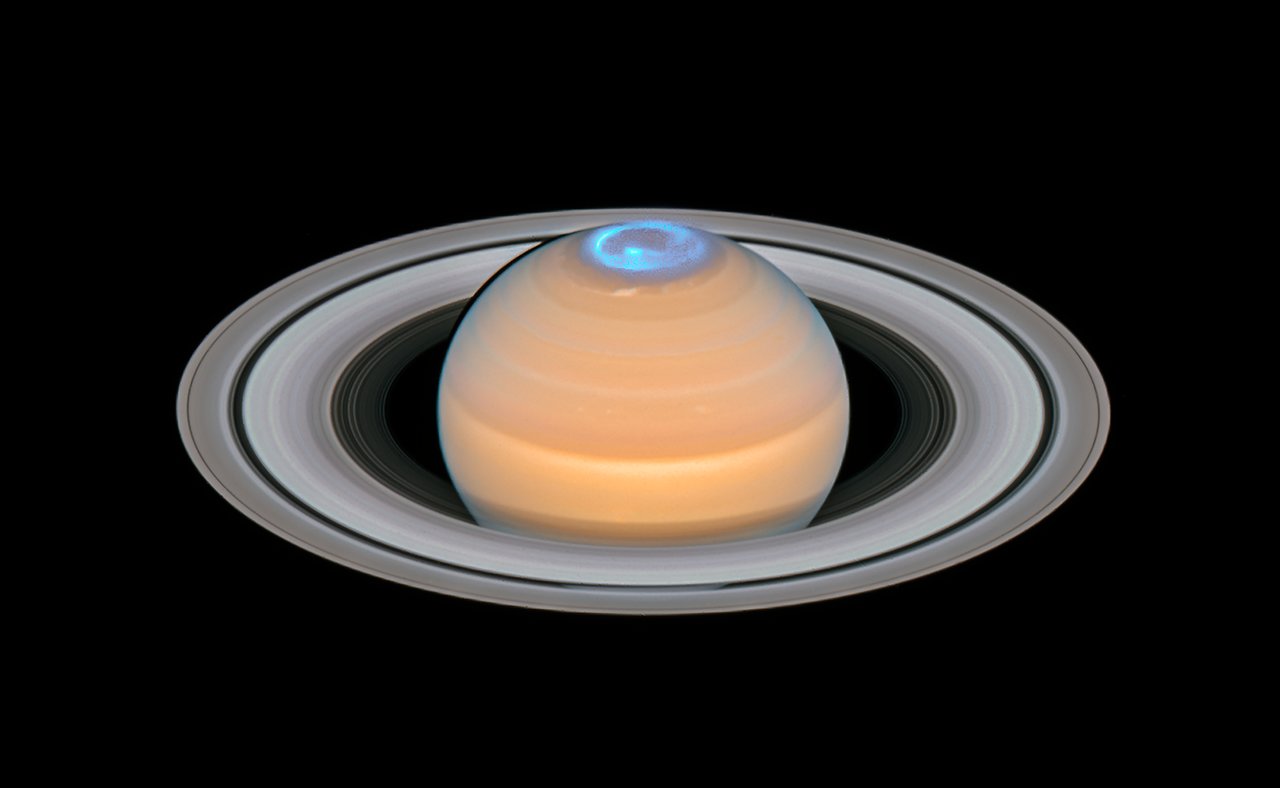 This image is a composite of observations made of Saturn in early 2018 in the optical and of the auroras on Saturn’s north pole region, made in 2017. Image from NASA/ESA Hubble Space Telescope