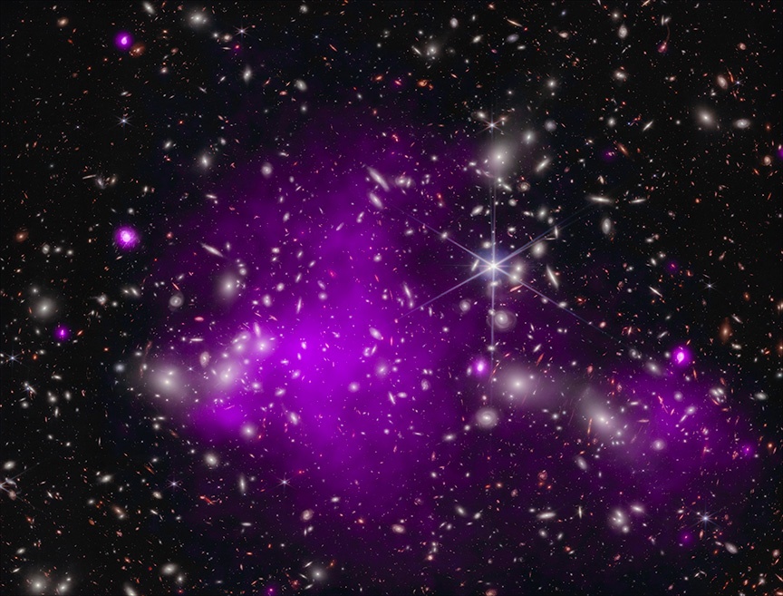 A composite Chandra and JWST image of a quasar whose light shone through an intervening galaxy cluster. The black hole at the heart of the quasar formed some 470 million years after the Big Bang. Credit: X-ray: NASA/CXC/SAO/Ákos Bogdán; Infrared: NASA/ESA/CSA/STScI; Image Processing: NASA/CXC/SAO/L. Frattare & K. Arcand