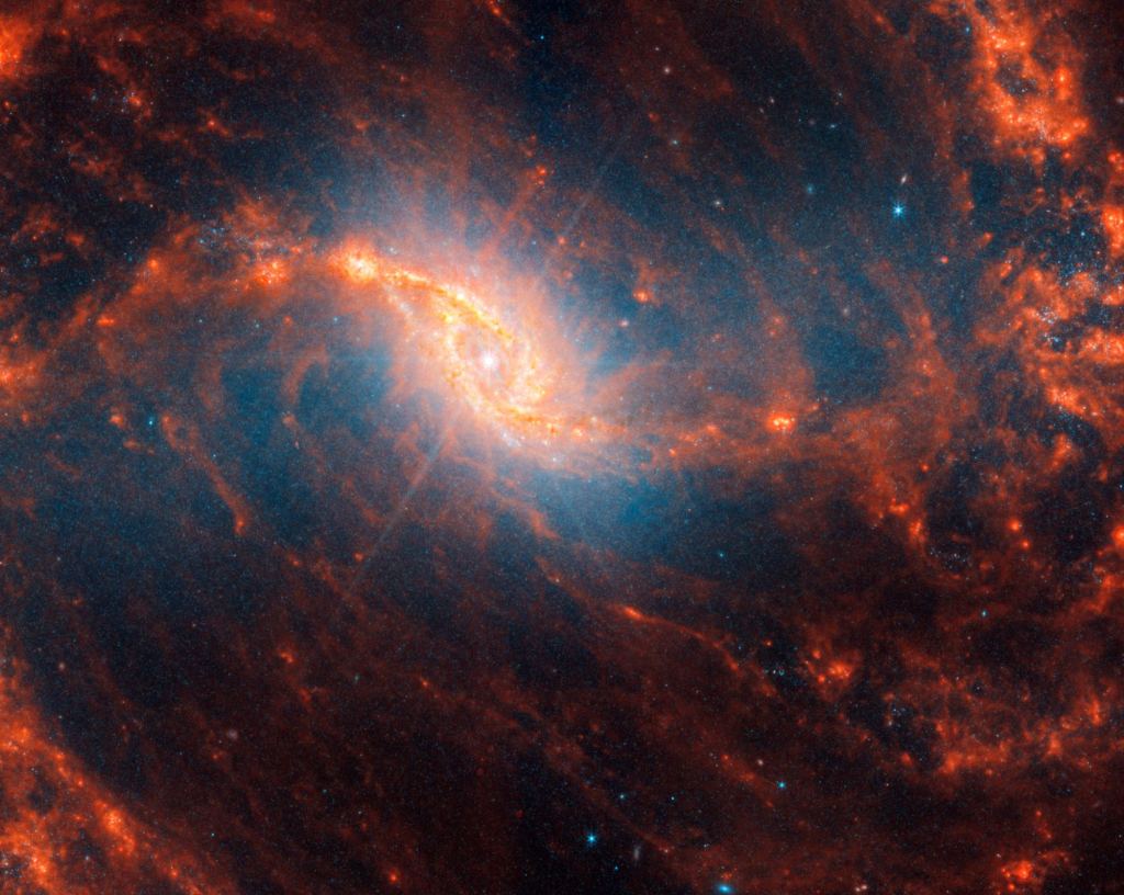 The diffraction spike in the center of NGC 1365 is a telescope artifact caused by an enormous amount of light in a compact region. It's caused by either the active supermassive black hole or tightly grouped stars in the galactic centre. NGC 1365 is a double-barred spiral galaxy about 74 million light-years away. Image Credit: NASA, ESA, CSA, STScI, Janice Lee (STScI), Thomas Williams (Oxford), PHANGS Team