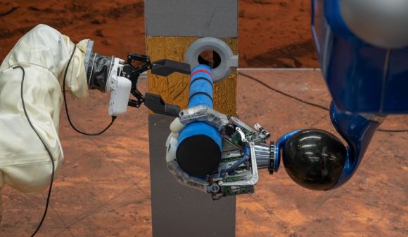 Colaboração bem-sucedida entre dois robôs inteligentes: O Interact Rover da ESA e o robô Rollin' Justin da DLR instalaram juntos um tubo curto que reproduz um dispositivo de medição científica. A tarefa foi coordenada pelo astronauta da ESA Marcus Wandt, que estava no controle da equipe de robôs no laboratório de Marte da DLR em Oberpfaffenhofen, a bordo da ISS.