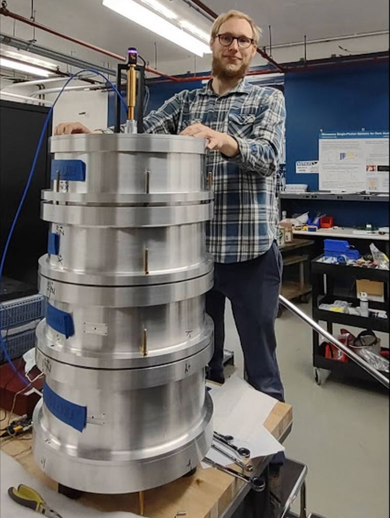 Fermilab's Stefan Knirck with components of the BREAD detector. Eventually, BREAD will be placed inside a magnet to boost the chances that dark photons will convert to photons. Image Credit: BREAD